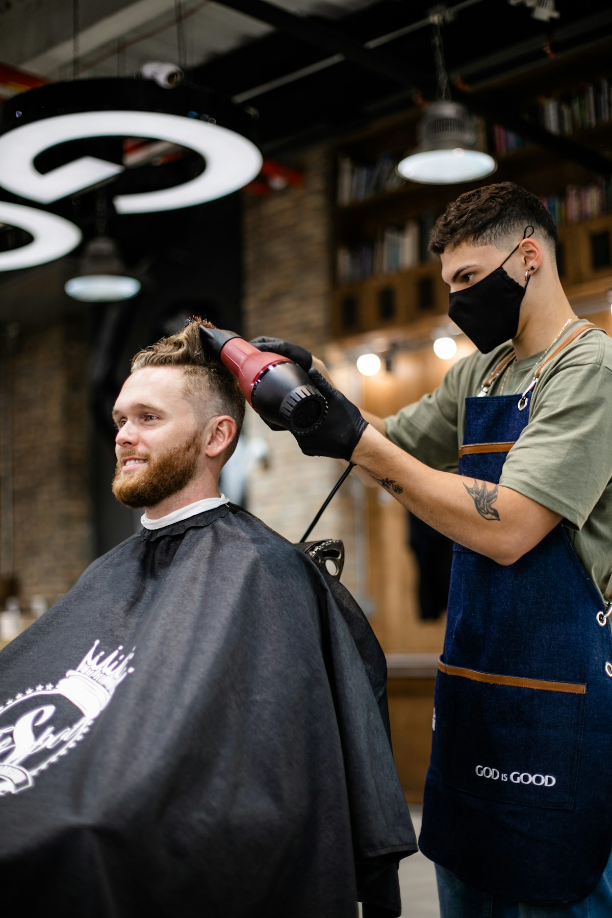 Barber styling a client's hair inside a barbershop